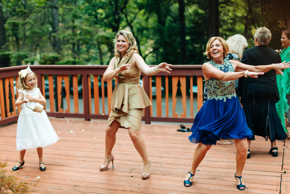 three generations of women dancing, including a flowergirl