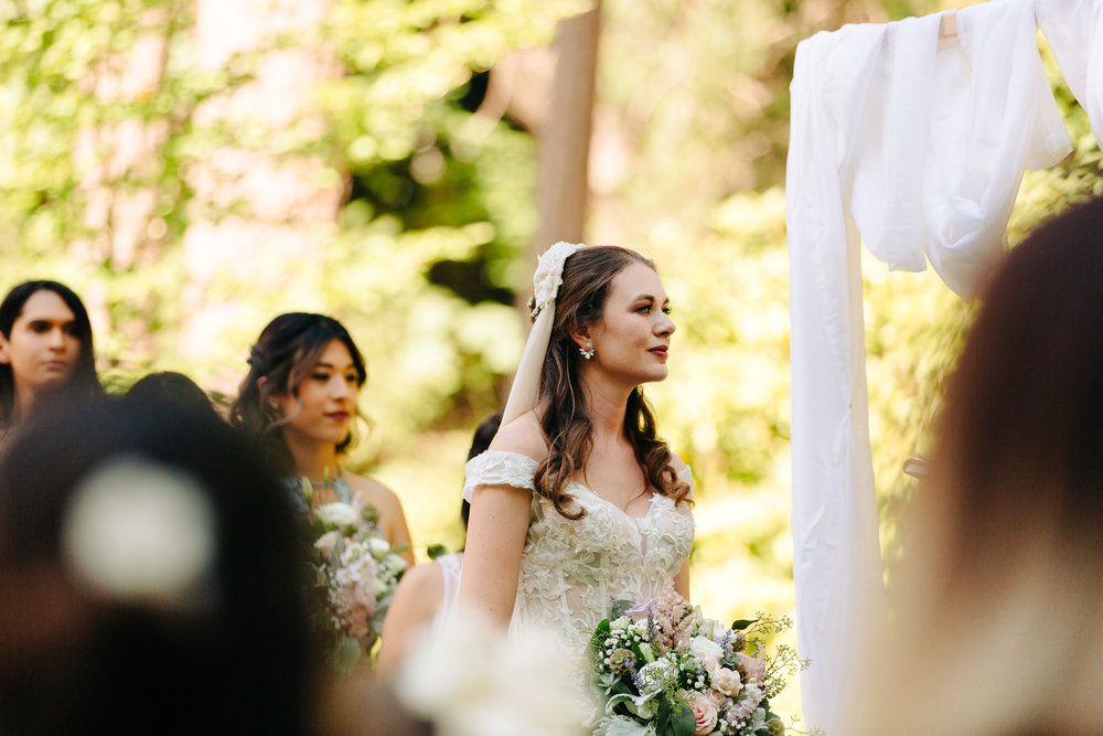 Candid shot of bride wearing Chic Bohemian Bride dress during outdoor ceremony