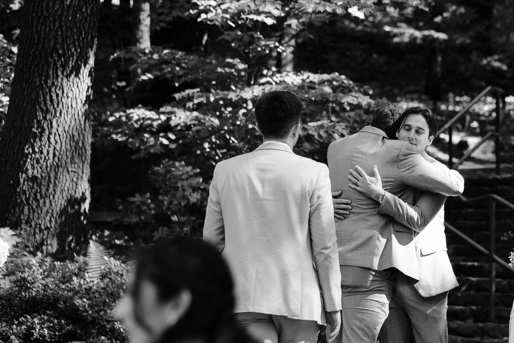 groom hugging groomsman after ceremony