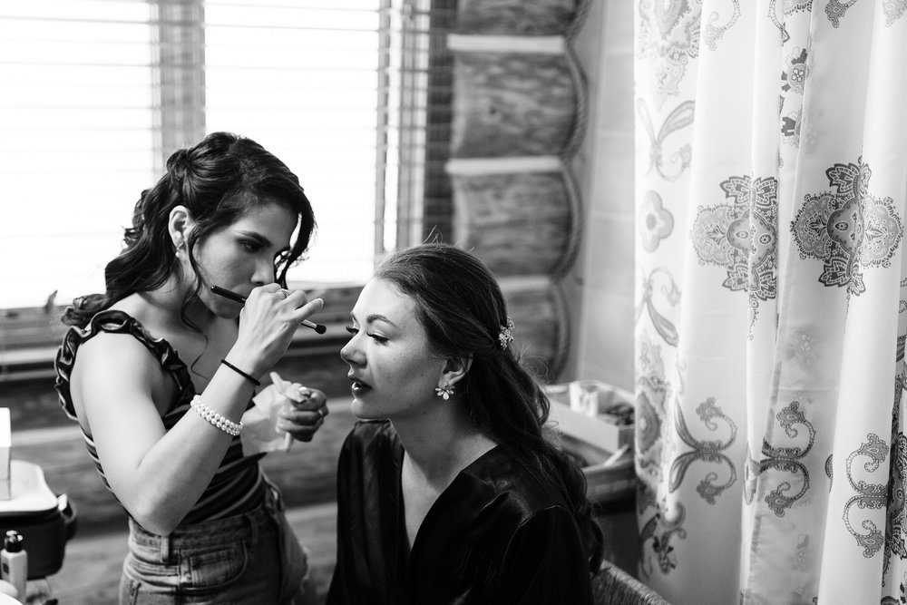 black and white photo of maid of honor doing bridal makeup