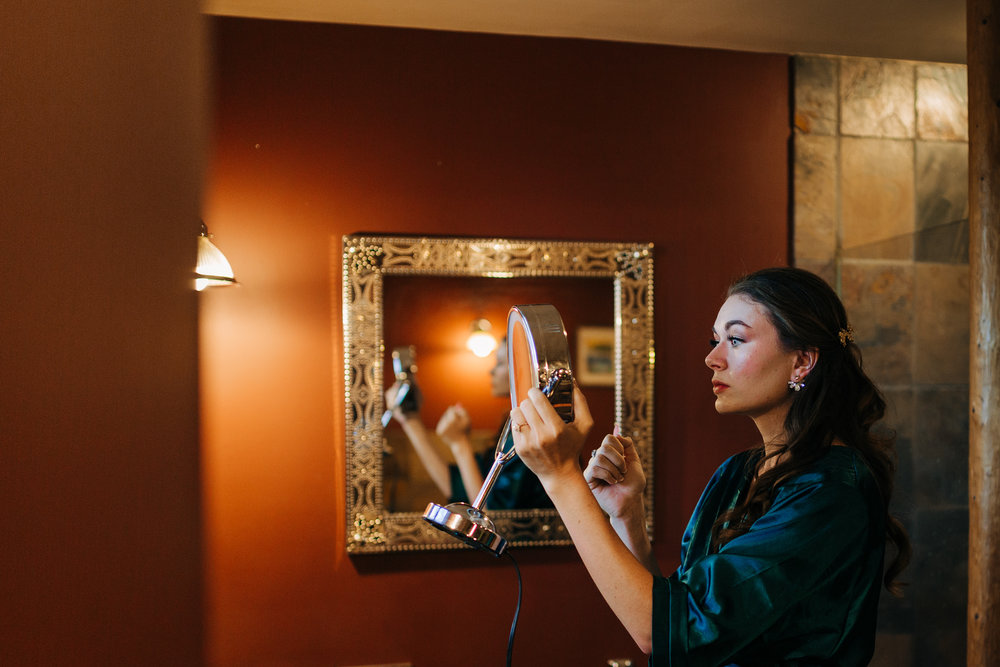 Bride putting on final makeup touches at Gilden Lodge near Mt. Shasta