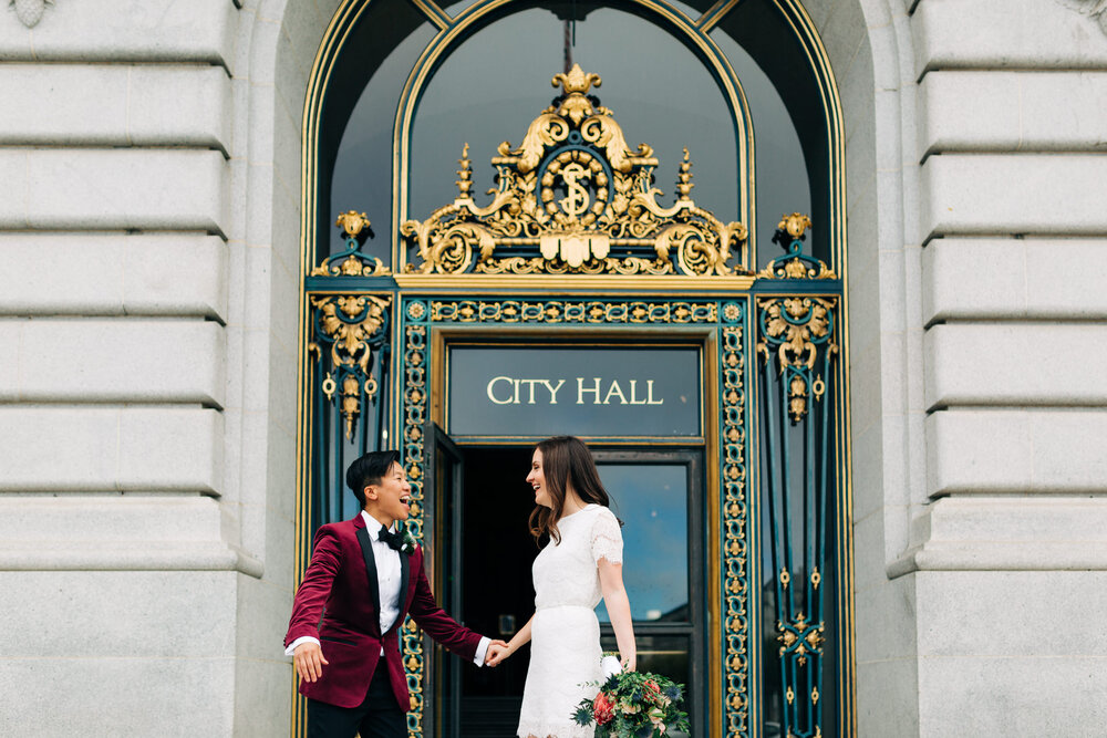 Newly-wed couple excited outside of the city hall doors