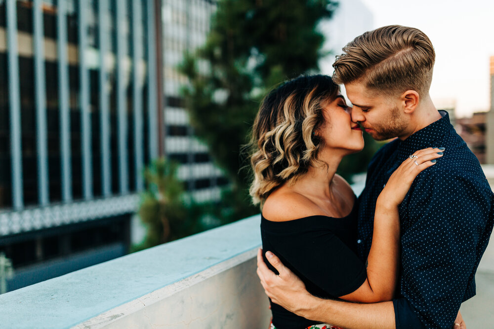 romantic portrait of couple at the edge of a rooftop downtown