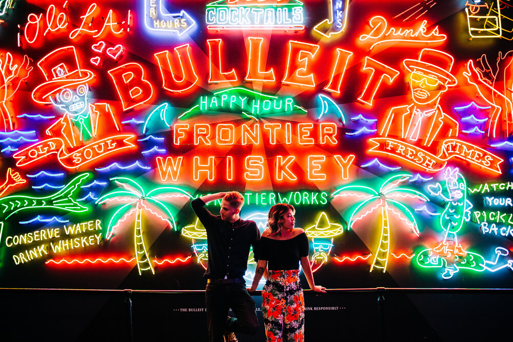 engaged couple in front of neon sign at Grand Central Market at night