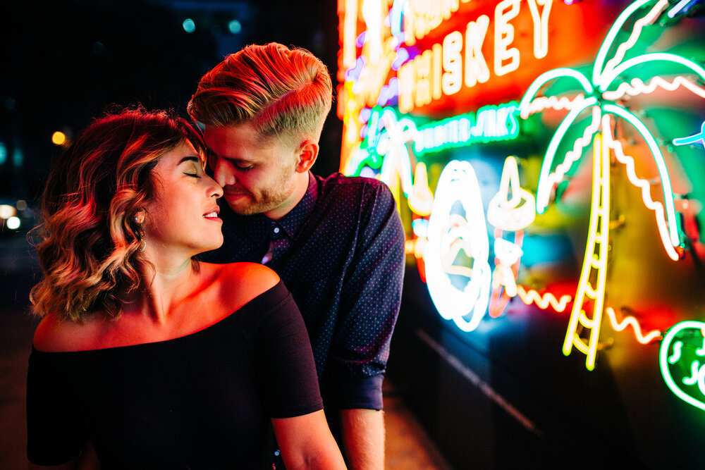 engaged couple in front of neon sign at Grand Central Market at night