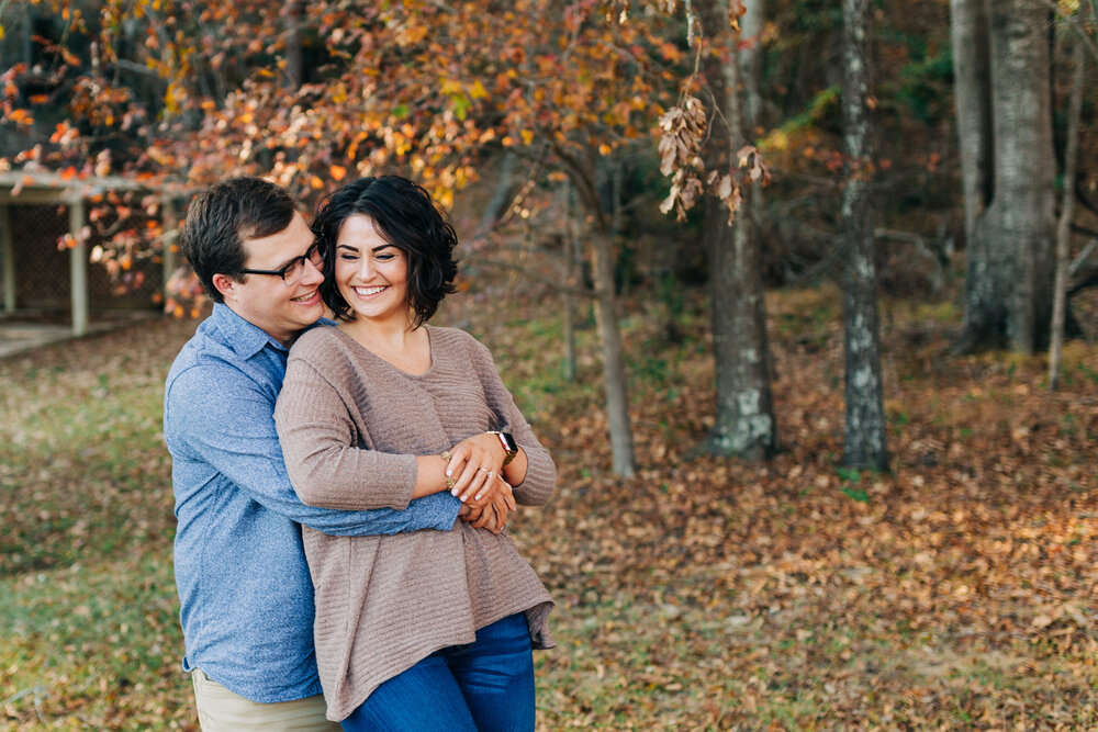 married couple in front of an outdoor fall backdrop