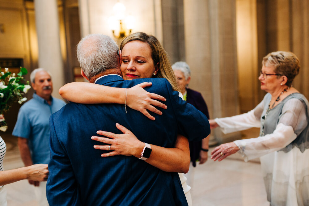 An emotional bride hugs her father after her ceremony