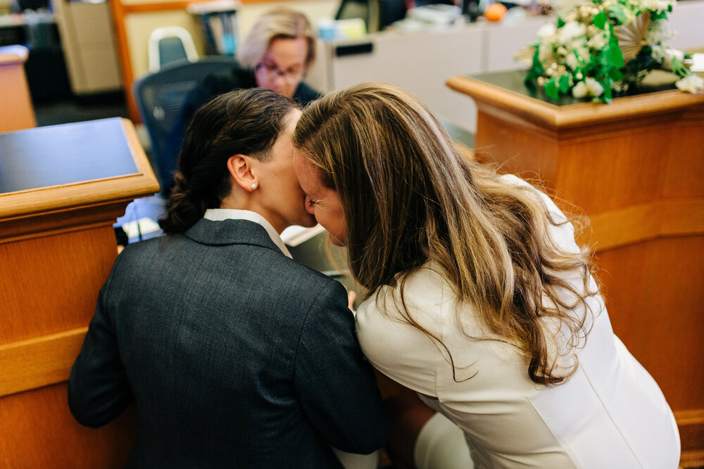 Two brides share a moment while they sign their marriage license at SF City Hall