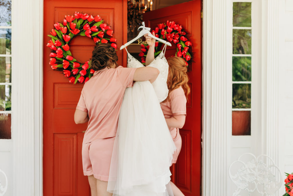 Candid bridesmaids and wedding dress entering Heartwood Hall by Sonum May Photography