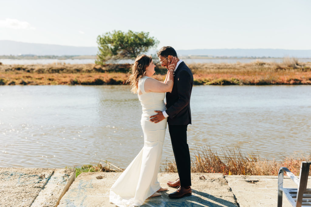 documentary style photography of couple embracing overlooking the water at a yacht club venue