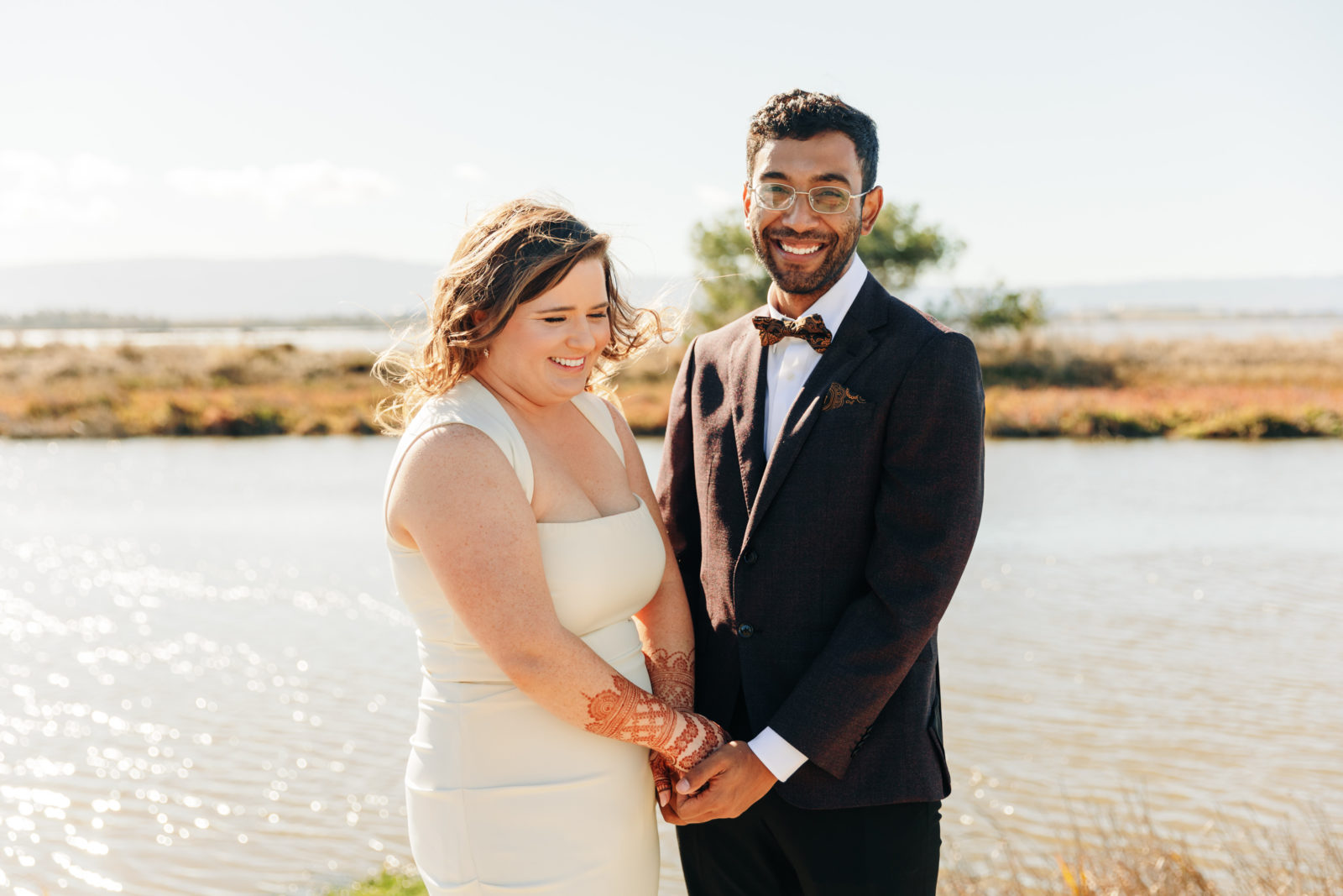 documentary style photography of couple laughing after a first look overlooking the water at a yacht club