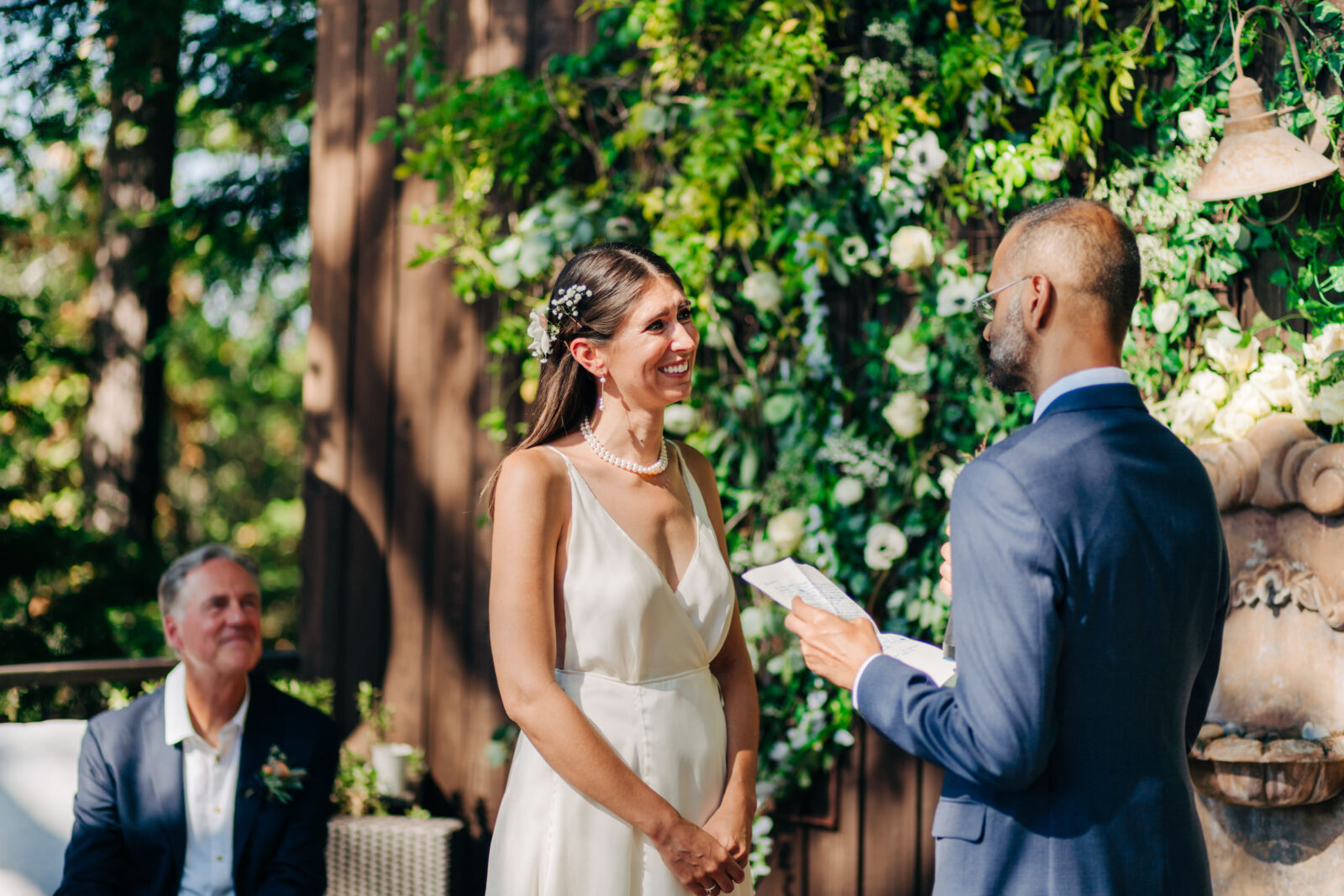 A bride smiles while hearing vows during her backyard wedding in Memphis