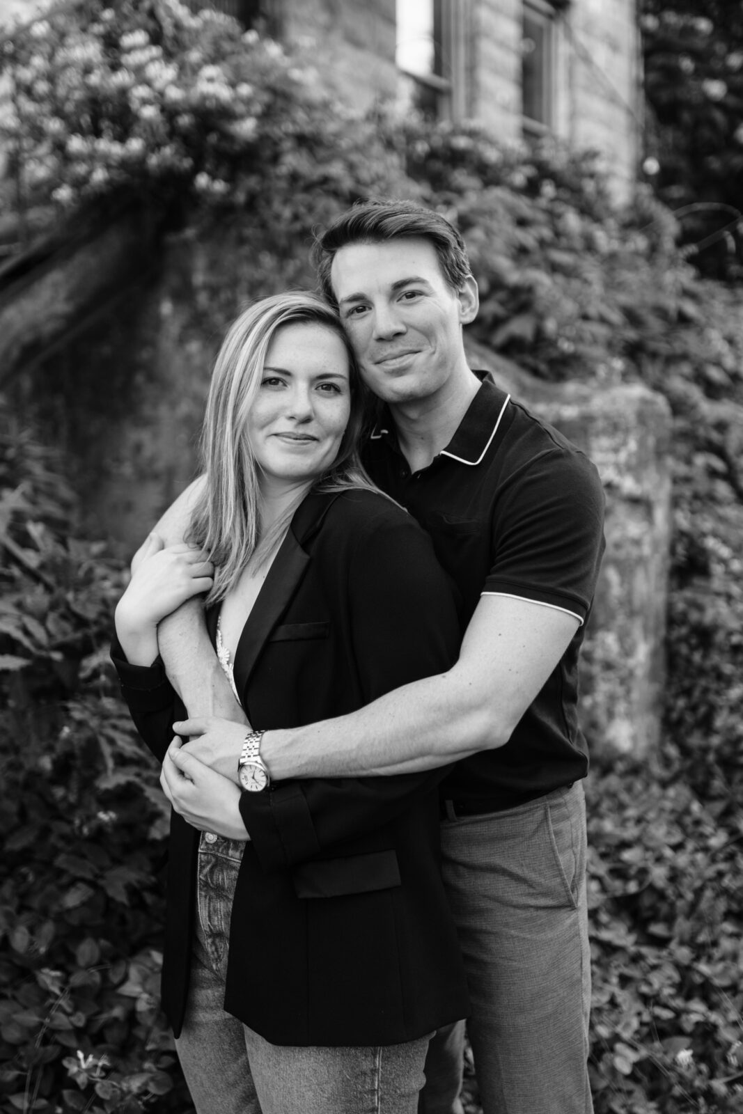 A black and white portrait of a couple hugging in front of a scene of greenery near South Main Street in Memphis