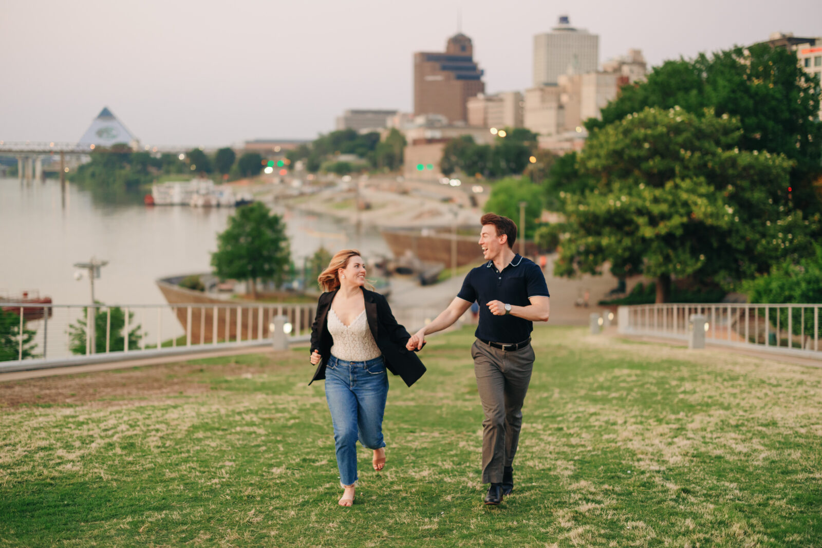 Engaged couple running along Beale Street Landing in downtown Memphis