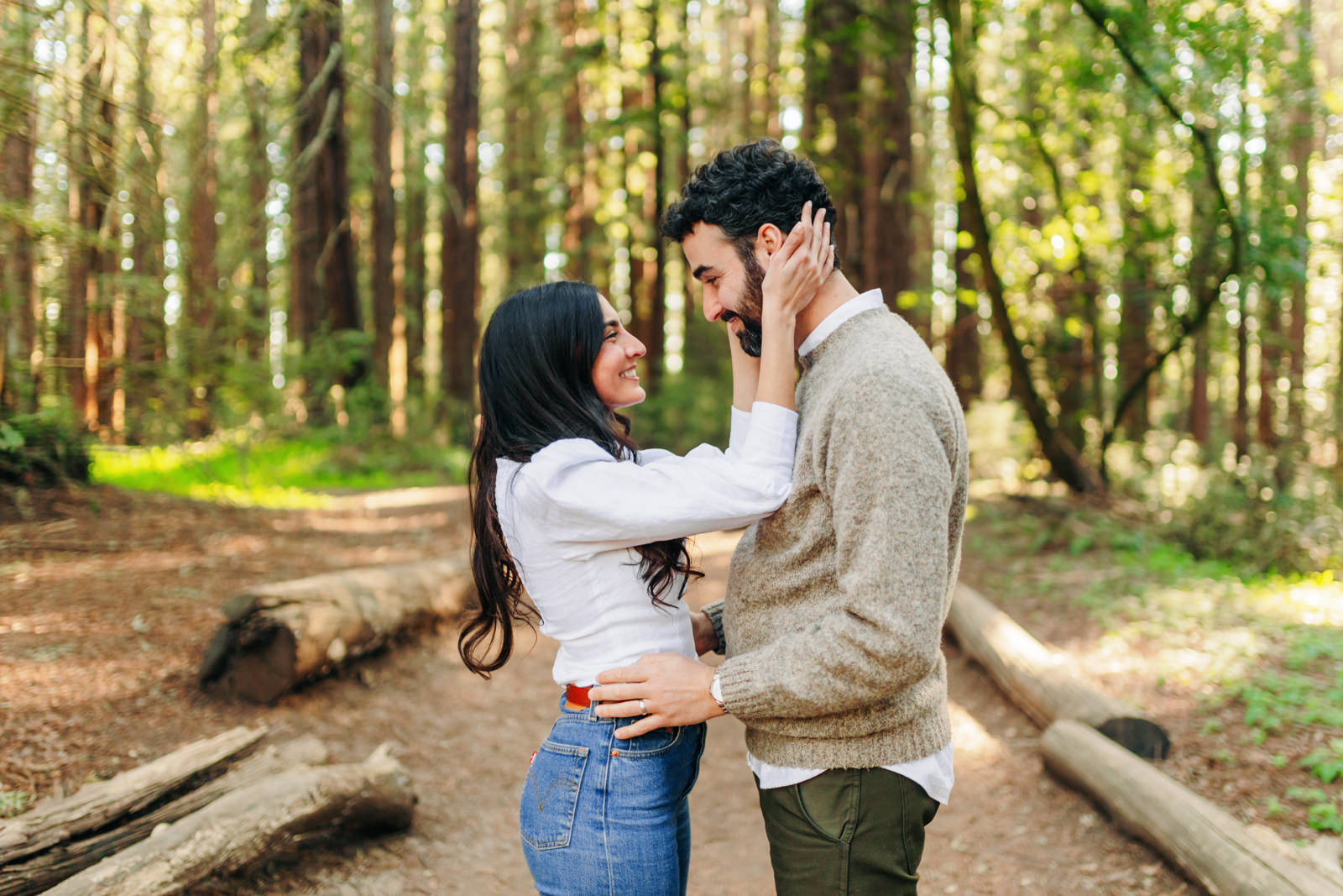 engagement session in wooded part of Shelby Farms Park featuring couple in neutral clothes hugging